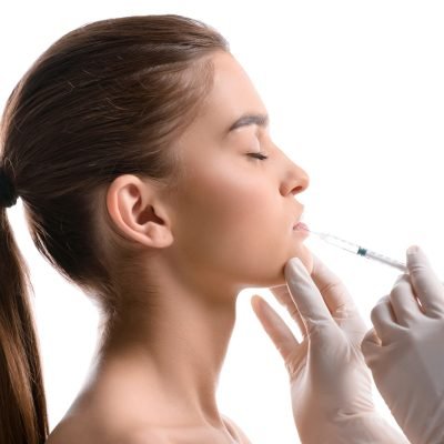 Portrait of attractive woman getting botox injection isolated on white